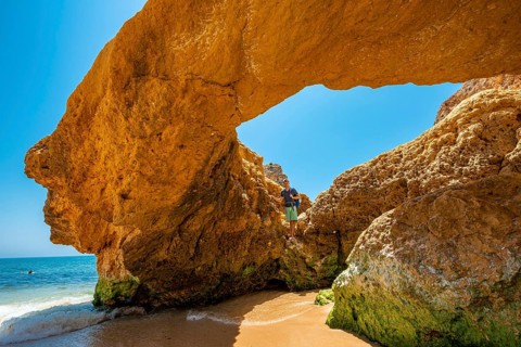 Young man standing in a rock cave with hole