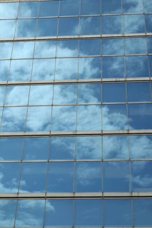 Glas facade with reflection of blue sky and clouds on a business building in Ginza district
