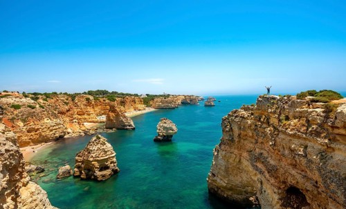 Young man standing on a rock on the cliff