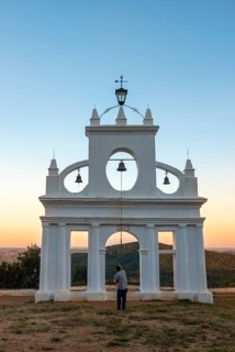 Bell ringer ringing the bells at the bell tower of the chapel Ermita Reina de los Angeles
