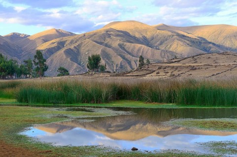 Reflection of bare hills in the Laguna Pumaqucha at the Inca ruins of Inti Watana