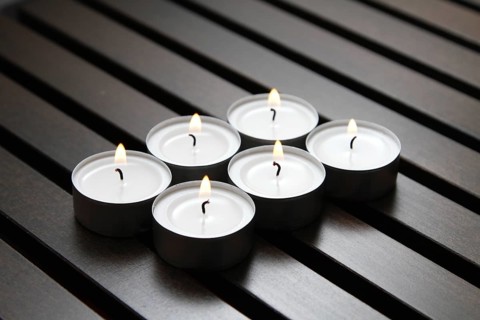 Tea lights on wooden background