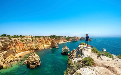 Young man standing on rocks on cliff