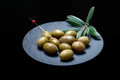 Greek olives from Chalkidiki on plate with toothpick
