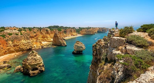Young man standing on rocks on cliff