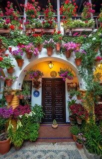 Entrance door and archway in courtyard decorated with flowers