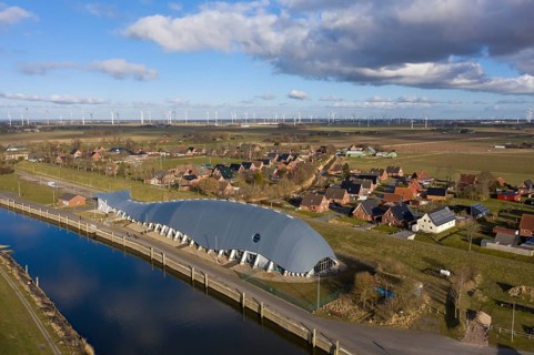 Aerial view of Friedrichskoog Rugenort with view of the indoor playground Willi and the Rugenort Loch in sunlight