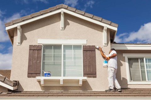 Busy house painter painting the trim and shutters of A home