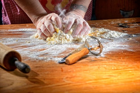 Cook kneading pasta dough on wooden table