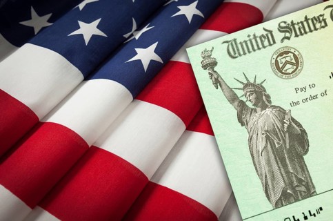 United states IRS stimulus check resting on american flag