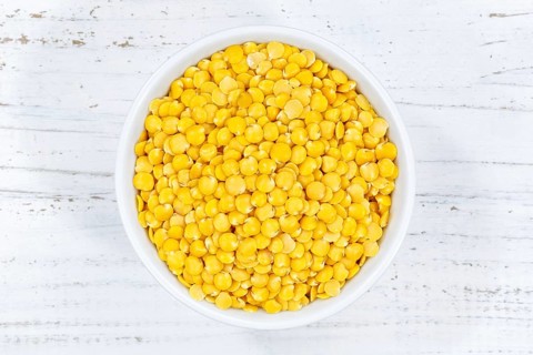 Yellow lentils raw from above wooden board
