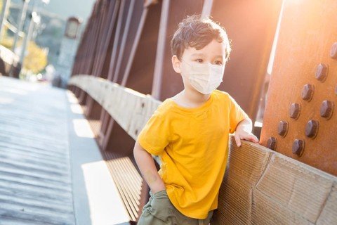 Young Mixed Race Chinese and Caucasian Boy Playing Alone Wearing Medical Face Mask Outside