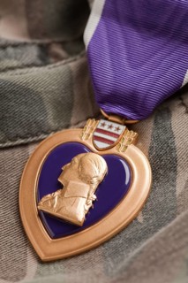 Purple heart war medal on camouflage material