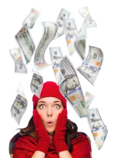 Young excited warmly dressed woman with $100 bills falling money around her on white