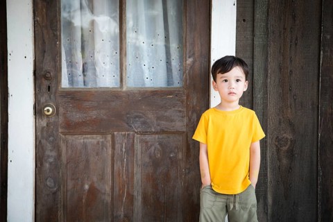 Mixed Race Chinese and Caucasian Boy Standing Alone on Porch