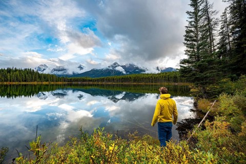 Hiker at the lakeside looking at mountains