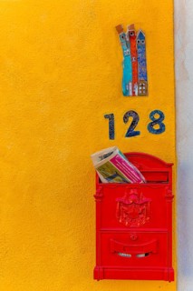 Letterbox and house number on a yellow house wall