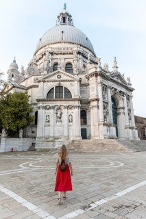 Young woman with red dress in front of church
