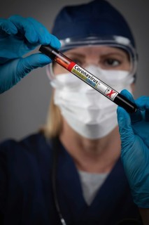 Female Lab Worker Holds Test Tube of Blood Labeled Coronavirus COVID-19 Disease