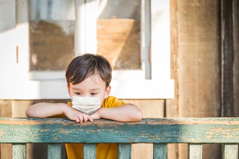 Young Mixed Race Chinese and Caucasian Boy Playing Alone Wearing Medical Face Mask Outside