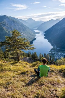Hiker sitting and looking at Plansee