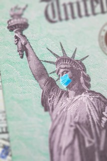 United states IRS stimulus check with statue of liberty wearing medical face mask