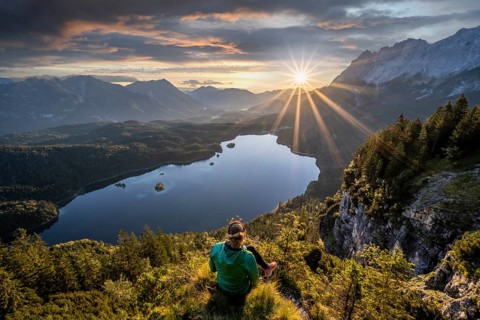Hiker looking at Eibsee lake at sunrise