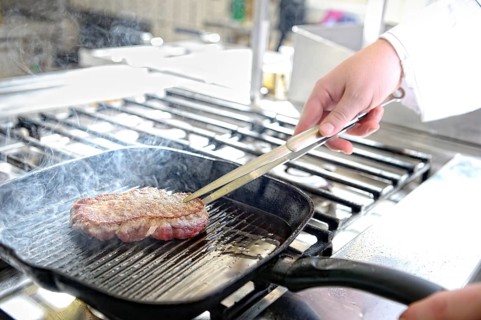 Steak in a grill pan while frying