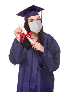 Graduating female wearing medical face mask and cap and gown isolated on a white background