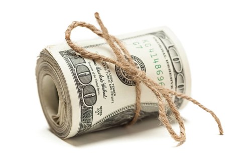 Roll of one hundred dollar bills tied in burlap string isolated on a white background