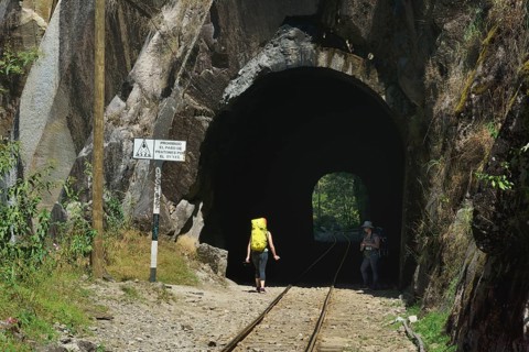 Tourists with backpack in the tunnel of the railway to Cusco