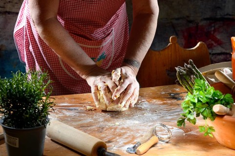 Cook kneading pasta dough for pasta on wooden table