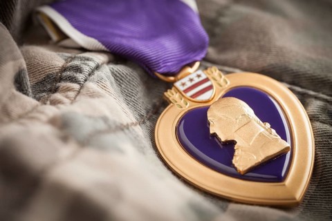 United states military purple heart medal resting on camouflage fatigues