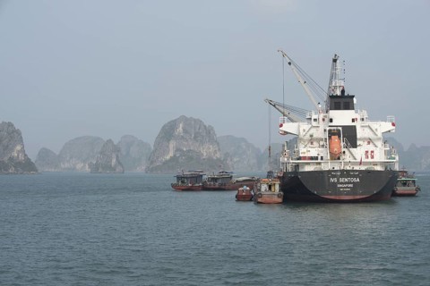 Supply ship loading or unloading cargo from coastal communities