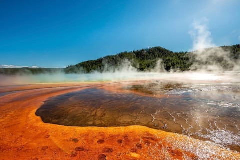 Steaming hot spring with colored mineral deposits