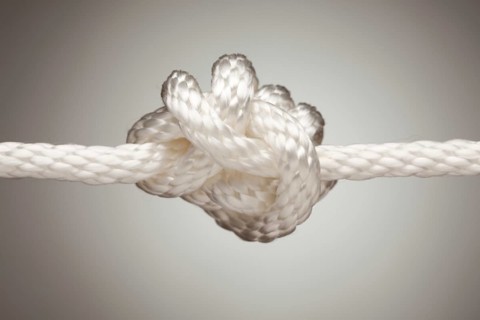 Nylon rope knot on a spot lit background