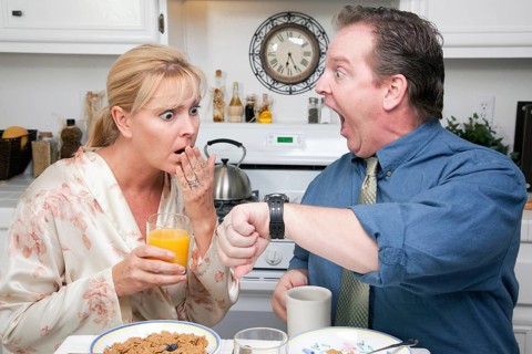 Late for work stressed couple checking time in kitchen