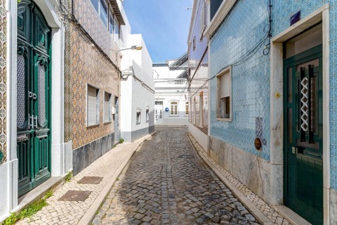 Narrow street with traditional fishermen's houses in Olhao
