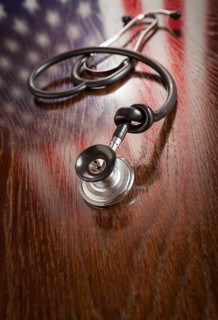 Knotted stethoscope with american flag reflection on wooden table