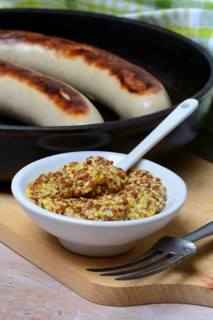Bowl of Dijon mustard and sausages