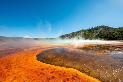 Steaming hot spring with colored mineral deposits