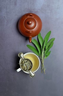 Sage tea in cup with tea strainer