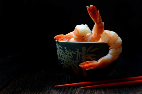 Cooked prawns in shell with chopsticks