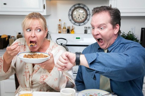 Late for work stressed couple checking time in kitchen