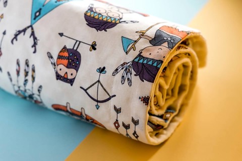 Sweet and cute baby blanket with Indian pattern isolated on yellow and blue background