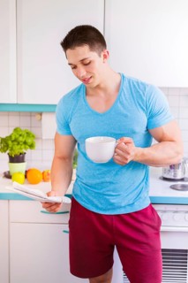 Newspaper reading coffee man reading in kitchen morning laugh in germany