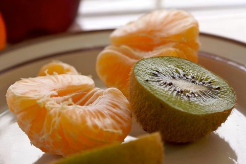 Kiwi and clementine tangerines on a plate in early morning light