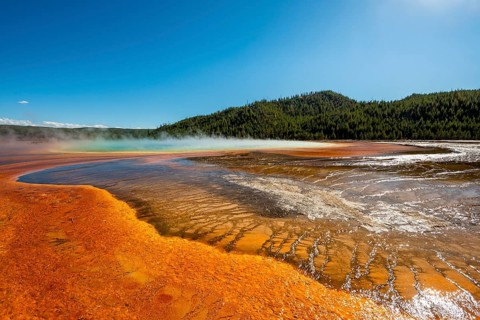 Steaming hot spring with colored mineral deposits