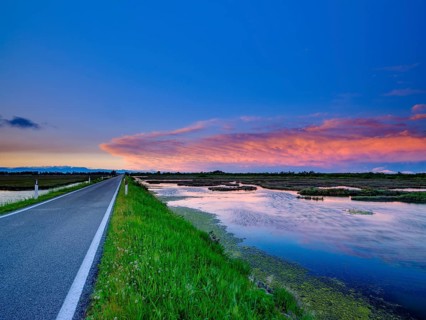 Lonely road and dramatic clouds over the lagoon of Venice