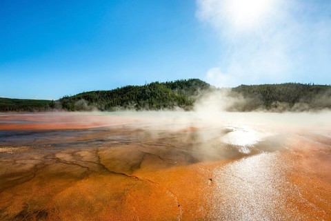 Steaming hot spring with colored mineral deposits